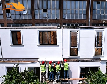 Workers Installing White Prefab Wall Panels